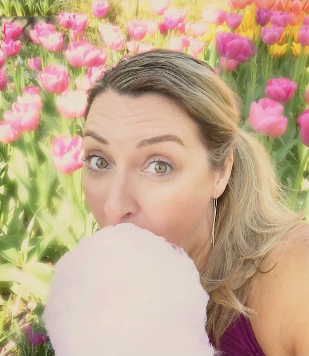 Allison eating cotton candy in a field of tulips