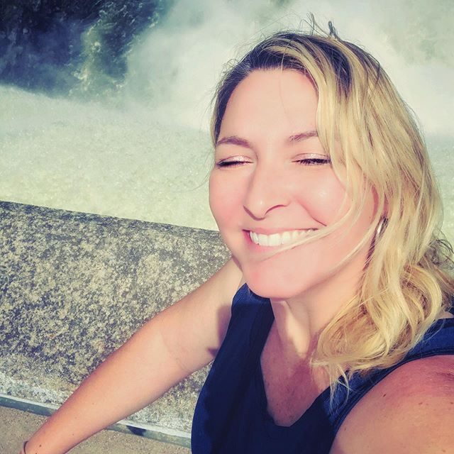 Allison laughing beside a creek